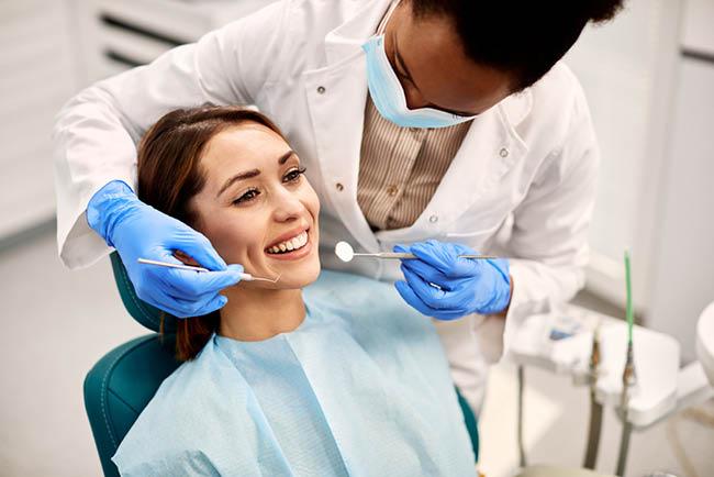 Dental - A woman sitting in a dentist chair having her teeth examined
